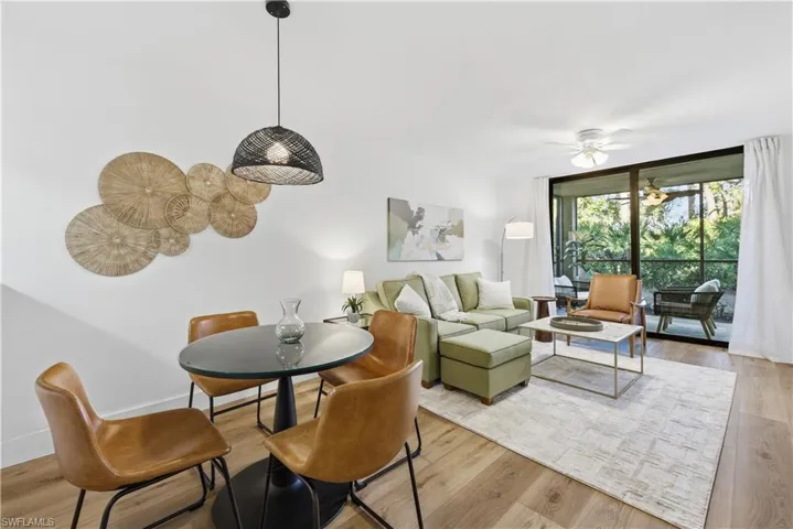 Dining area with ceiling fan, light wood finished floors, and expansive windows