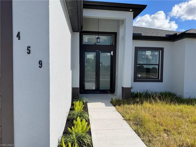 Doorway to property with french doors and stucco siding