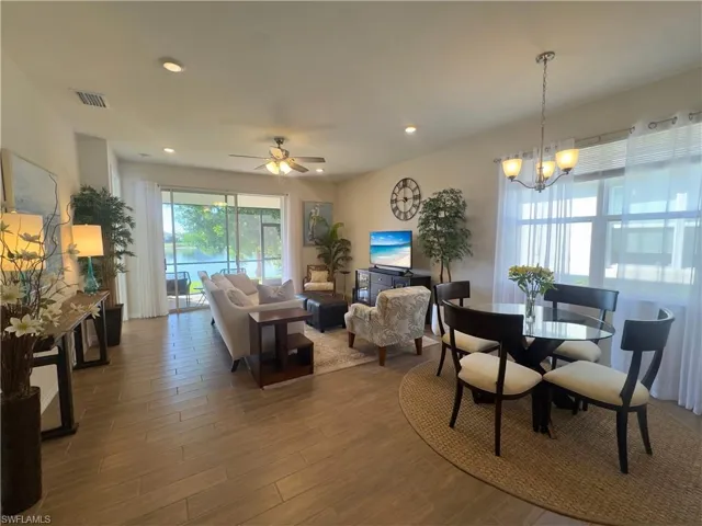 Dining space featuring wood finished floors, a ceiling fan, recessed lighting, and a chandelier