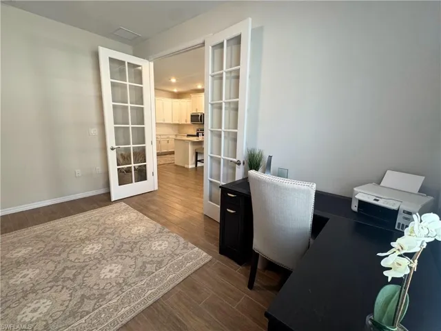 Office space with french doors and dark wood-style flooring