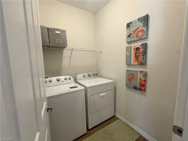 Washroom with baseboards and washing machine and dryer