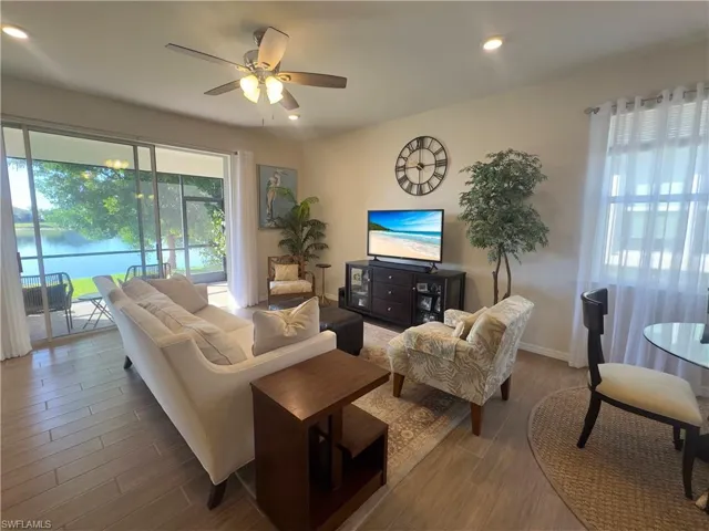 Living room featuring wood finish floors, ceiling fan, recessed lighting, and a water view