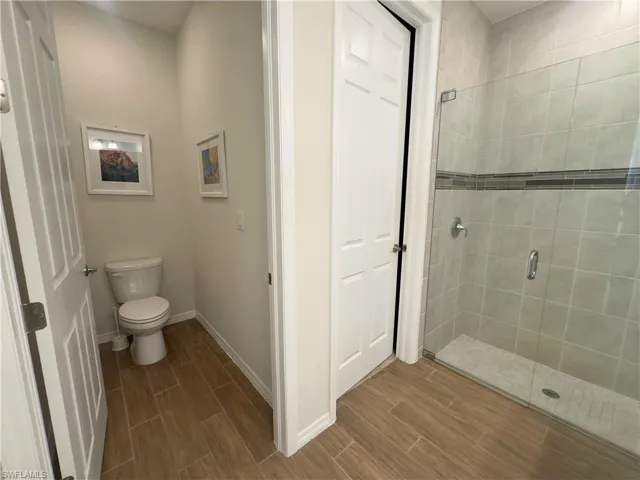 Bathroom featuring a shower stall and wood tiled floors
