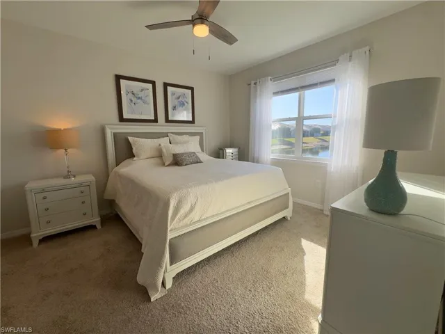Carpeted bedroom featuring a water view and ceiling fan