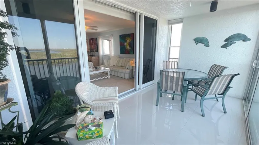 Balcony featuring a water view and outdoor dining area