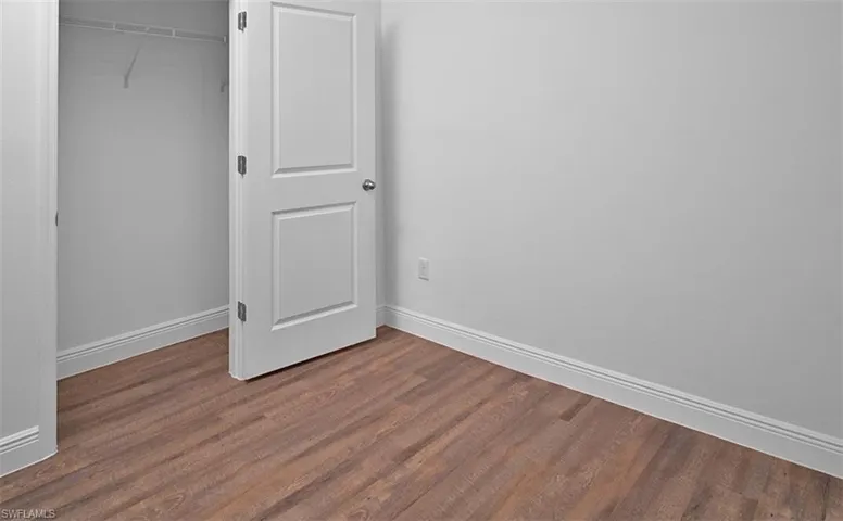 Unfurnished bedroom with dark wood finished floors and a closet