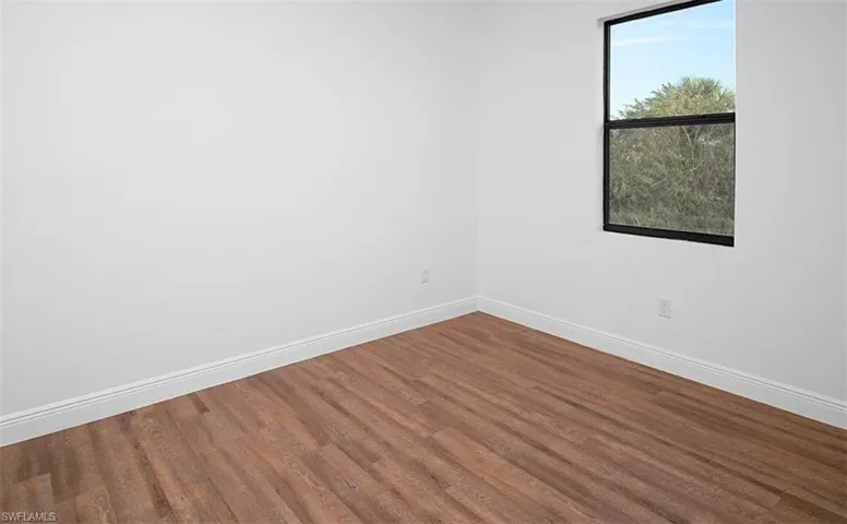 Empty room with baseboards and wood finished floors
