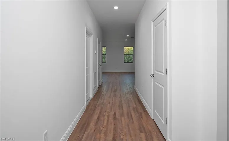 Hallway featuring dark wood-style floors and recessed lighting