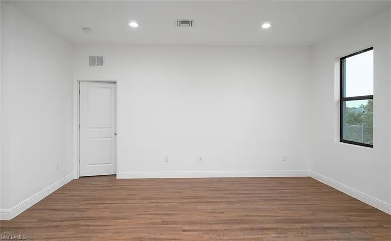 Spare room featuring dark wood-style floors and recessed lighting