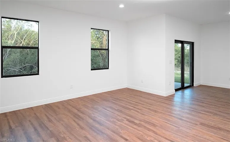 Unfurnished room featuring healthy amount of natural light, wood finished floors, and recessed lighting