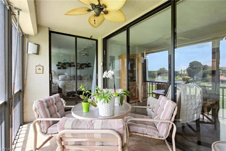 Screened patio featuring a ceiling fan, outdoor wall sconce, and sliding glass doors