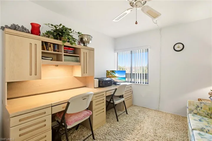 Built-in desk unit featuring wood-finish cabinetry, integrated shelving, and task lighting