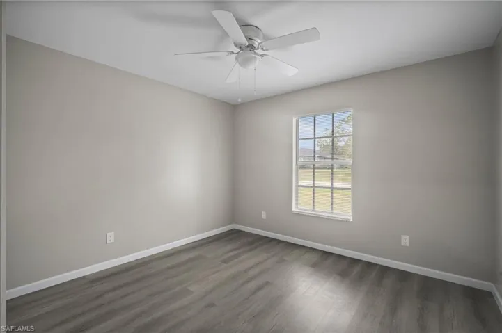 Spare room featuring dark hardwood / wood-style flooring and ceiling fan