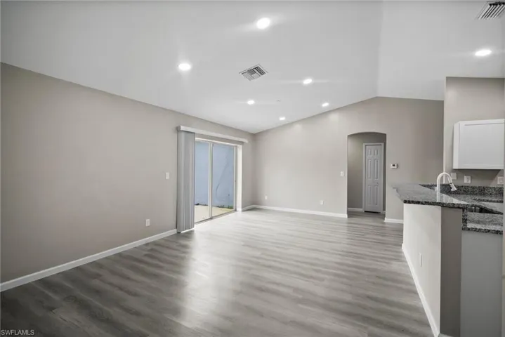 Unfurnished living room with vaulted ceiling and dark hardwood / wood-style floors