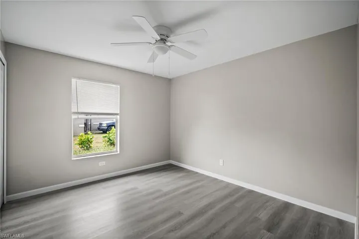 Unfurnished room with ceiling fan and wood-type flooring