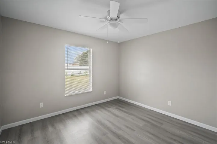 Unfurnished room with hardwood / wood-style floors and ceiling fan