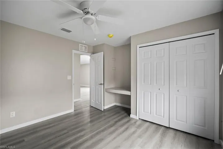 Unfurnished bedroom with a closet, light hardwood / wood-style floors, and ceiling fan