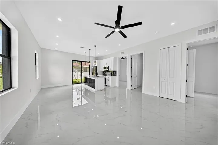 Unfurnished living room with light marble finish flooring, recessed lighting, and a ceiling fan