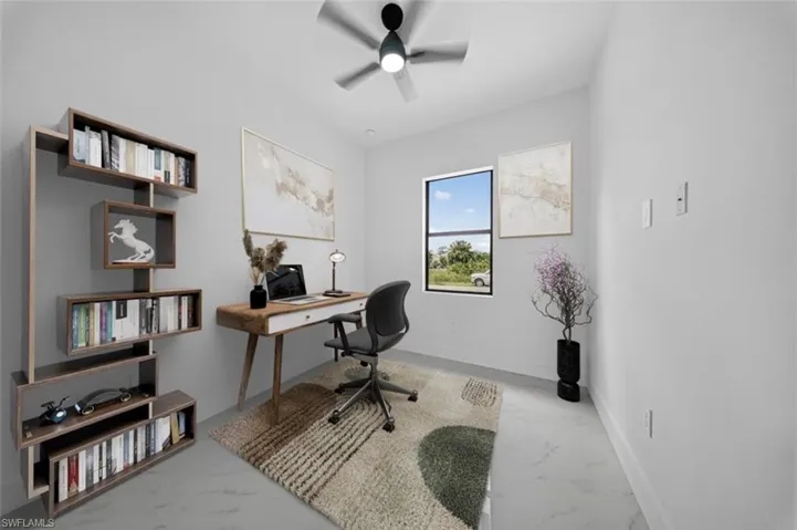 Office space featuring light marble finish floors and a ceiling fan