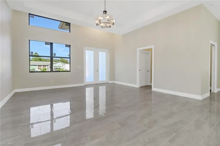 Spare room featuring a towering ceiling and a chandelier