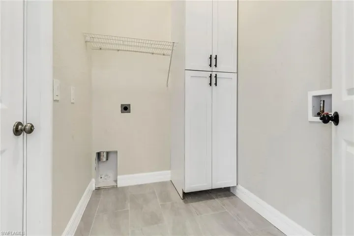 Washroom featuring washer hookup, electric dryer hookup, and cabinets