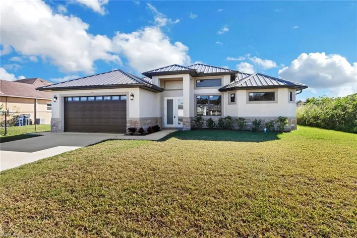 View of front of house featuring a front yard and a garage