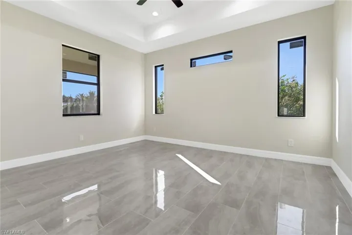 Unfurnished room with ceiling fan and a wealth of natural light