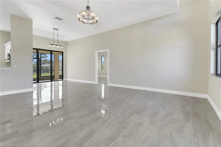 Unfurnished living room featuring an inviting chandelier
