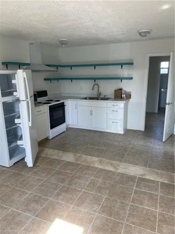 Empty room featuring tile floors and sink