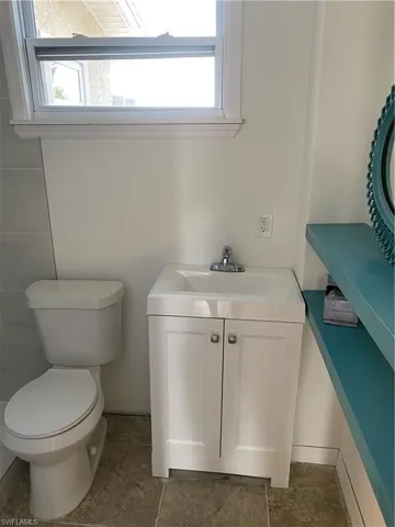 Bathroom with tile flooring, vanity, and toilet