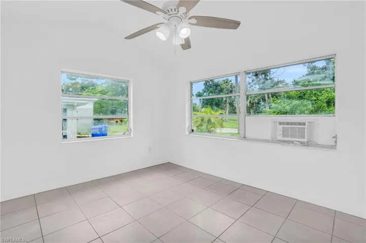 Spare room with lofted ceiling, ceiling fan, cooling unit, and tile patterned flooring