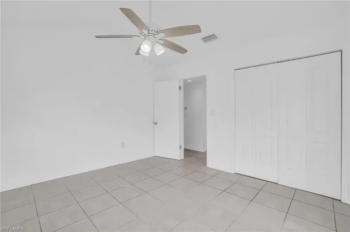 Unfurnished bedroom with a closet, light tile patterned floors, and ceiling fan