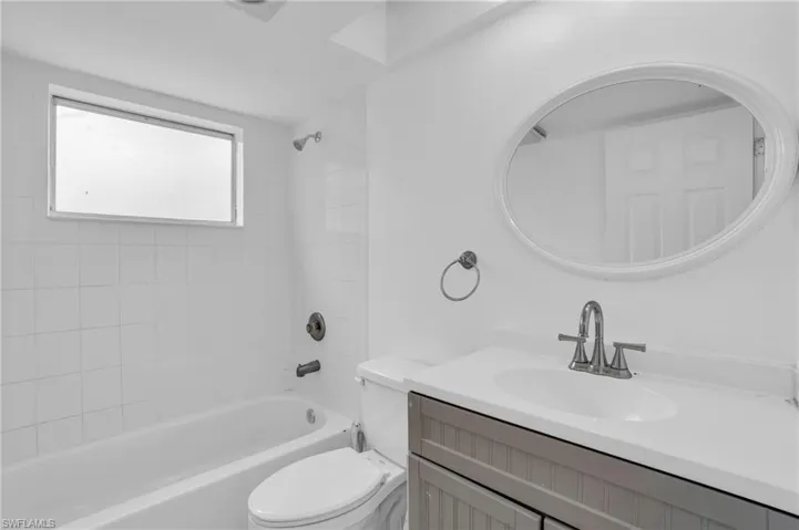 Full bathroom featuring vanity, tiled shower / bath, and toilet
