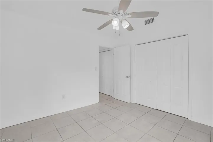 Unfurnished bedroom featuring a closet, ceiling fan, and light tile patterned floors