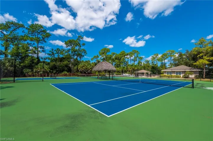 View of tennis court with a gazebo, fence, and community basketball court