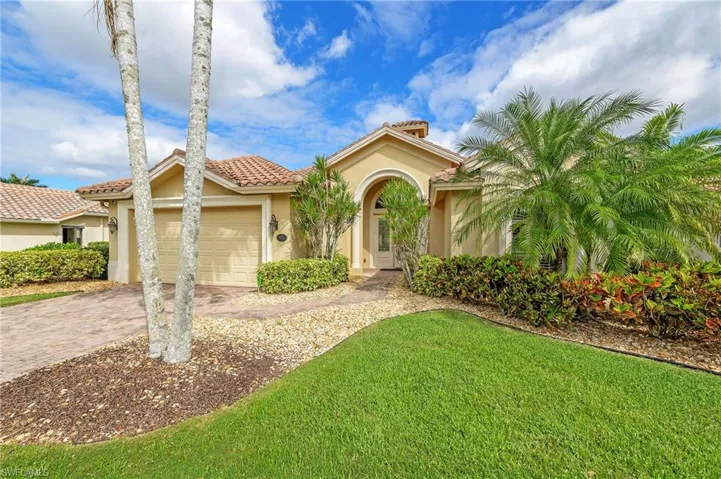 Mediterranean / spanish house featuring stucco siding, decorative driveway, an attached garage, a tile roof, and a front lawn