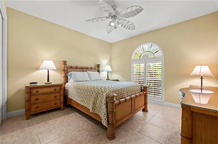 Bedroom with baseboards, a ceiling fan, and light tile patterned floors