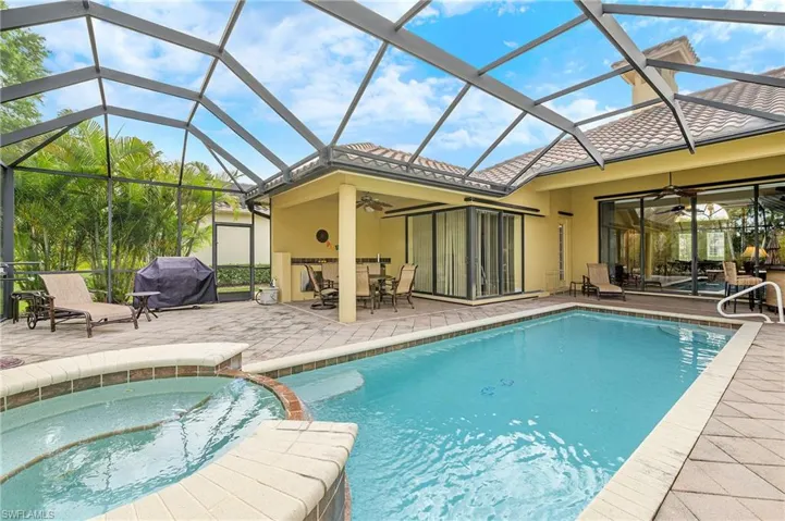 View of pool featuring ceiling fan, grilling area, a patio area, and a pool with connected hot tub