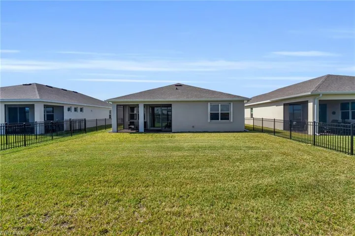 Rear view of property with a sunroom and a lawn