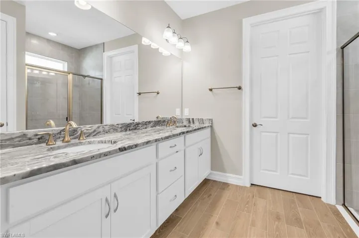 Bathroom featuring vanity and a shower with door