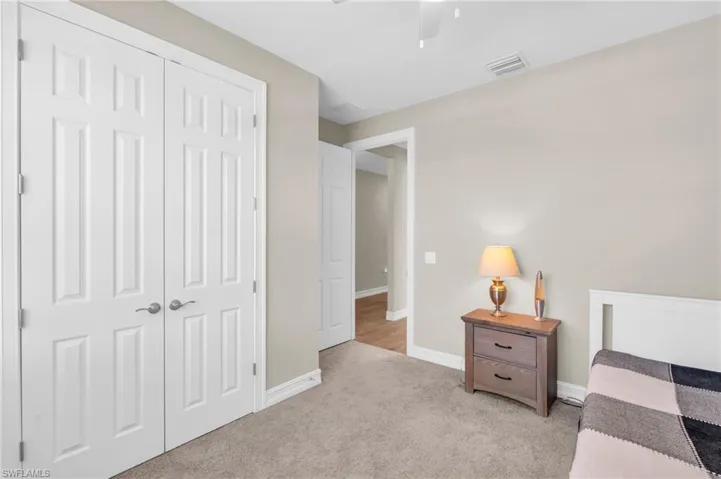 Bedroom featuring a closet, ceiling fan, and light colored carpet