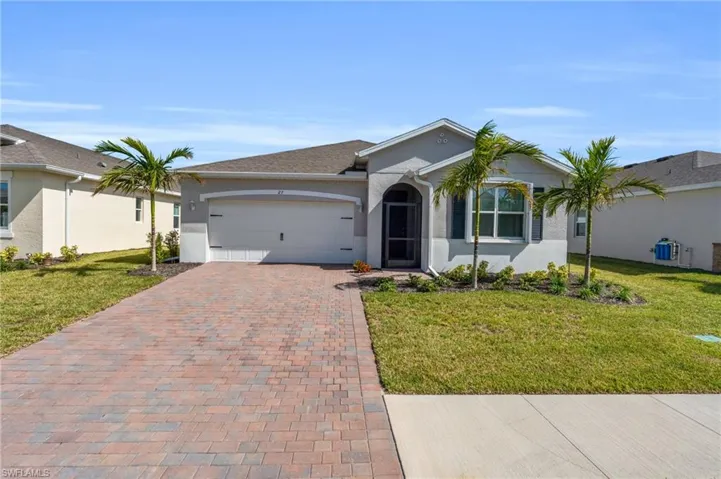 Ranch-style house with a garage and a front lawn