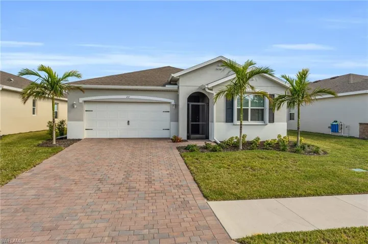 Ranch-style house featuring a front yard and a garage