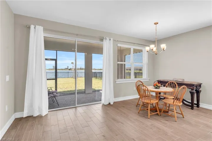 Dining space featuring a water view, light hardwood / wood-style flooring, and a chandelier