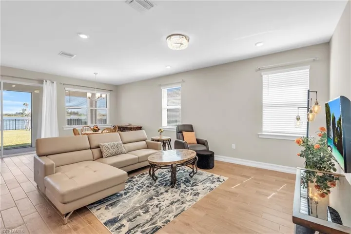 Living room featuring a wealth of natural light, light hardwood / wood-style flooring, and an inviting chandelier