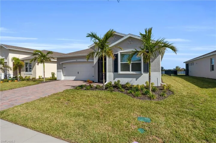 View of front of home featuring a front lawn and a garage