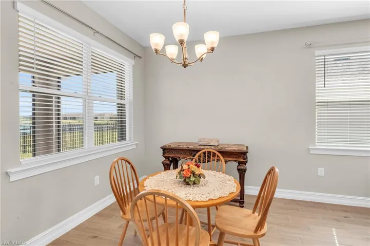 Dining area with light hardwood / wood-style floors, an inviting chandelier, and plenty of natural light