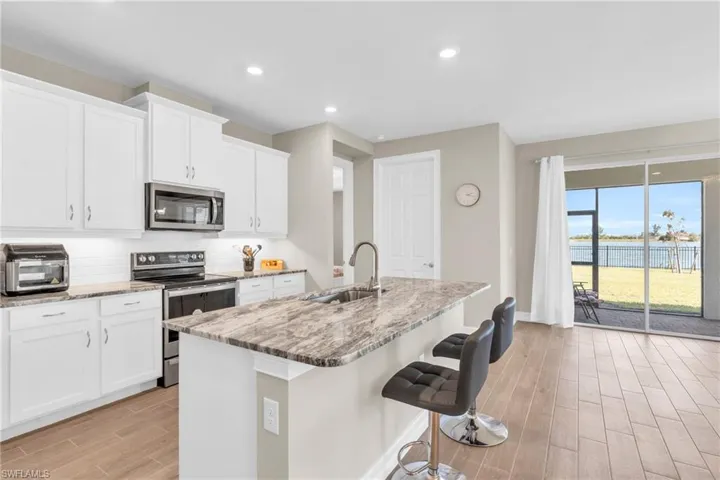 Kitchen featuring sink, appliances with stainless steel finishes, a kitchen island with sink, and light wood-type flooring