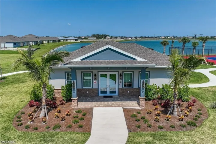View of front of home featuring a water view, a porch, and a front lawn