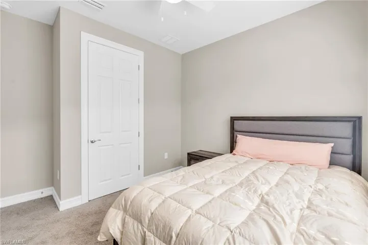 Carpeted bedroom featuring ceiling fan